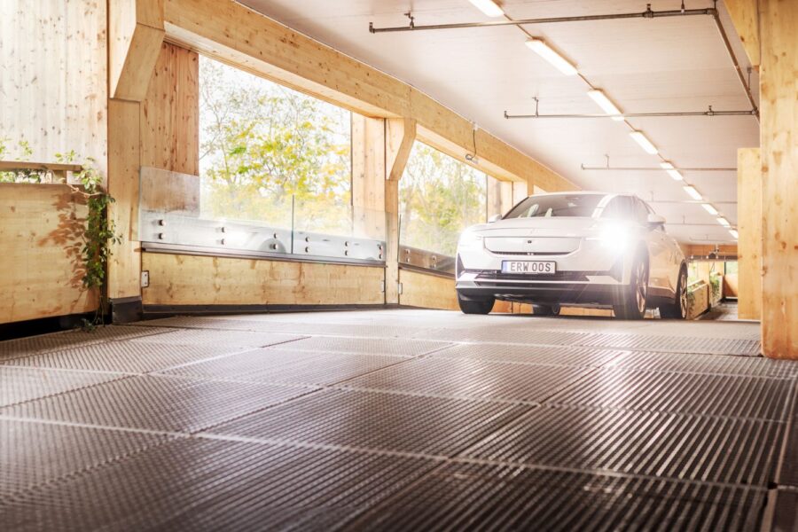 Auto fährt mit angeschalteten Scheinwerfern in einem Parkhaus die Rampe hinauf