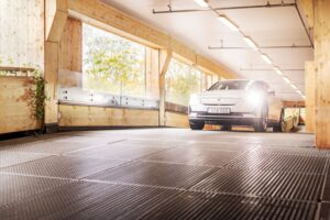 Car drives up the ramp in a parking garage with the headlights on