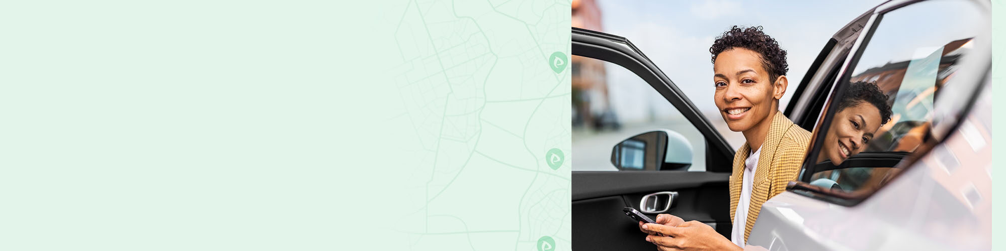 Kvinna sitter i sin bil med parkeringsapp i hand
