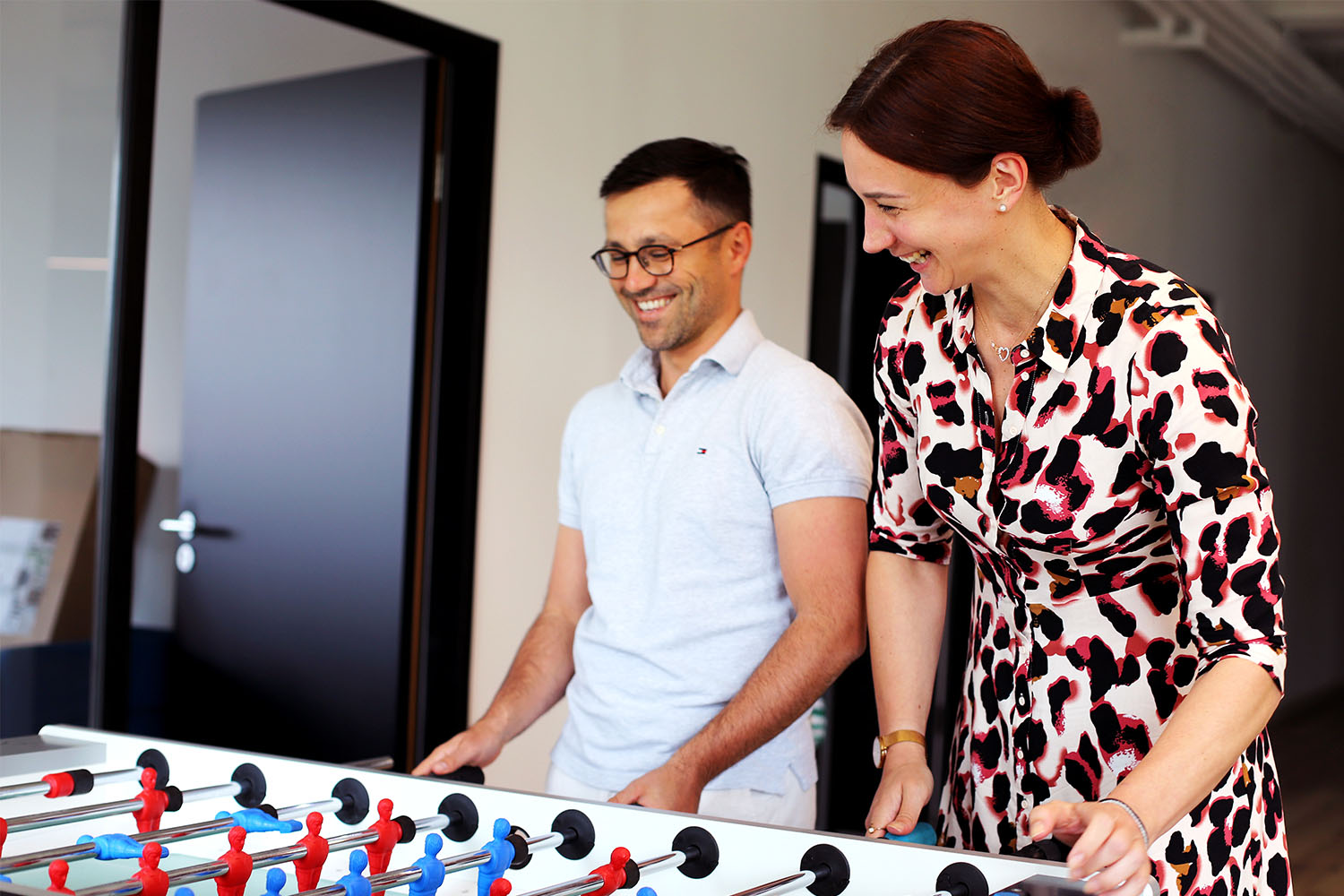 Två kollegor spelar en match foosball
