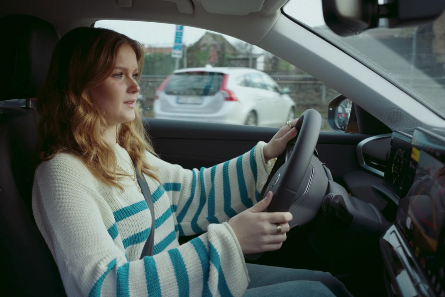Ung tjej som sitter i bil. Ska ta körkort.